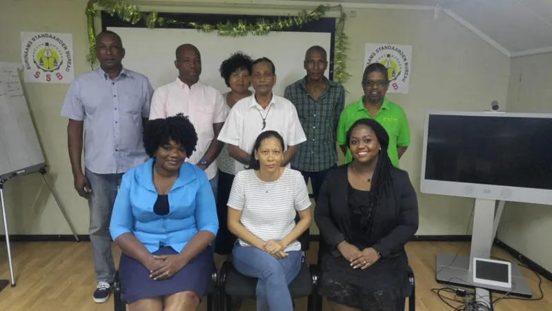 Group photograph in front of Suriname Standards Bureau banners